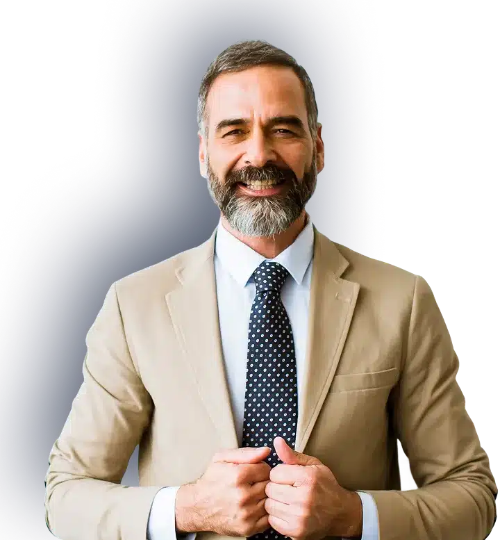 A smiling man with a gray beard and hair wears a tan suit, white shirt, and polka-dot tie.